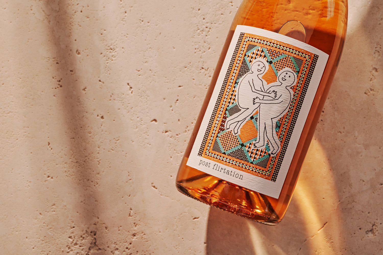 A wine bottle with a colorful label featuring two abstract figures embracing, set against a textured beige background. The tone is playful and artistic.